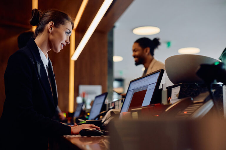 Hotel employee using a computer at the front desk